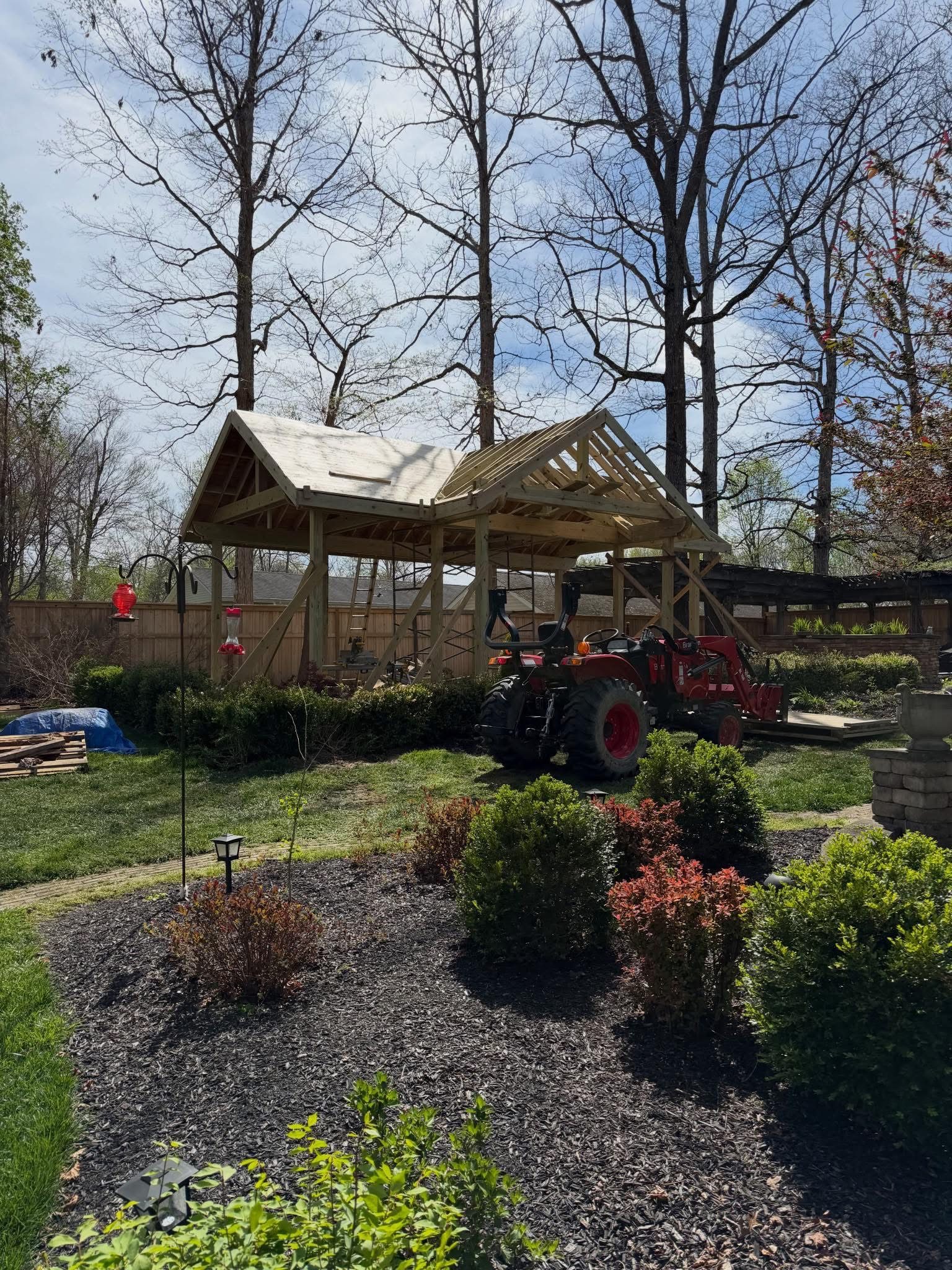Same outdoor pavilion during construction, mid-roof framing